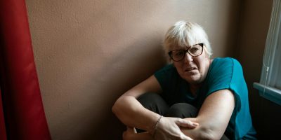 Portrait of an adult woman in thought, representing survival and strength indoors.