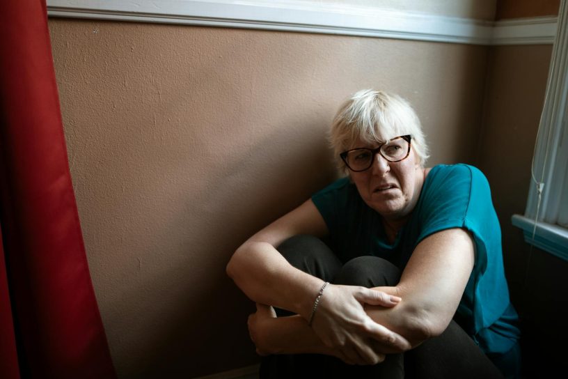 Portrait of an adult woman in thought, representing survival and strength indoors.